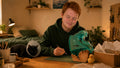 Charlie working at his desk while Millie the cat recovers nearby